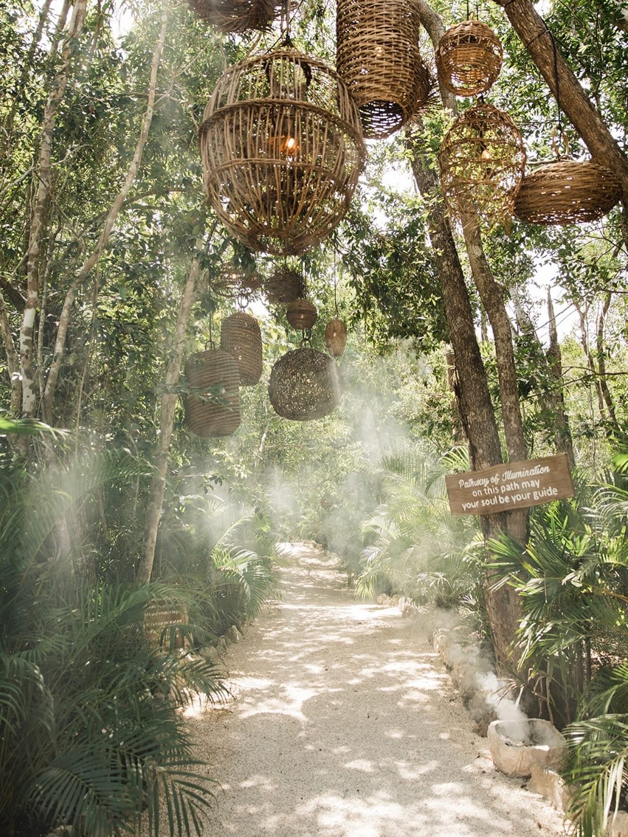 The Pathway of Illumination by day, woven lanterns overhead and copal smoke across the path
