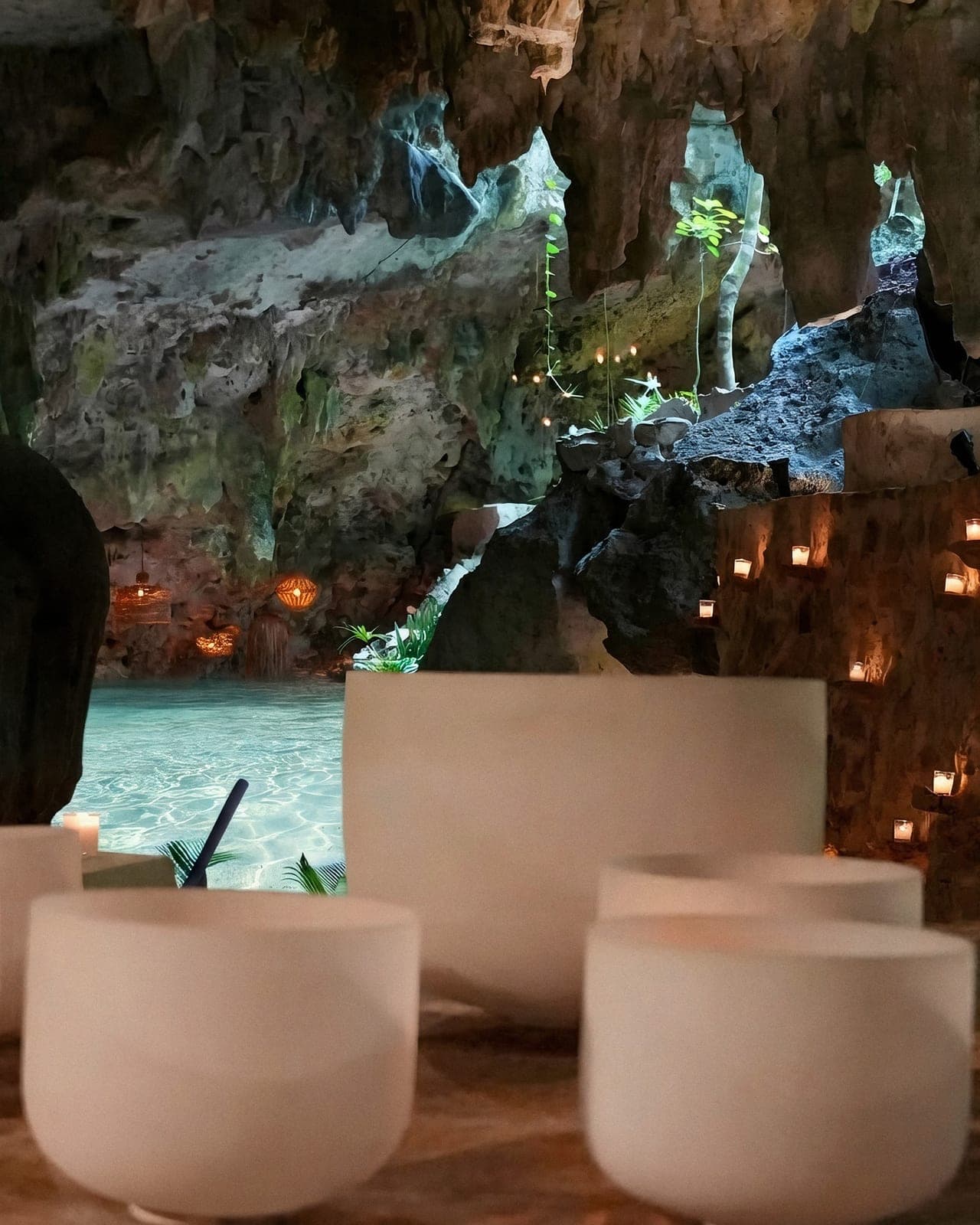 Quartz singing bowls in the foreground, the cenote and the cave beyond