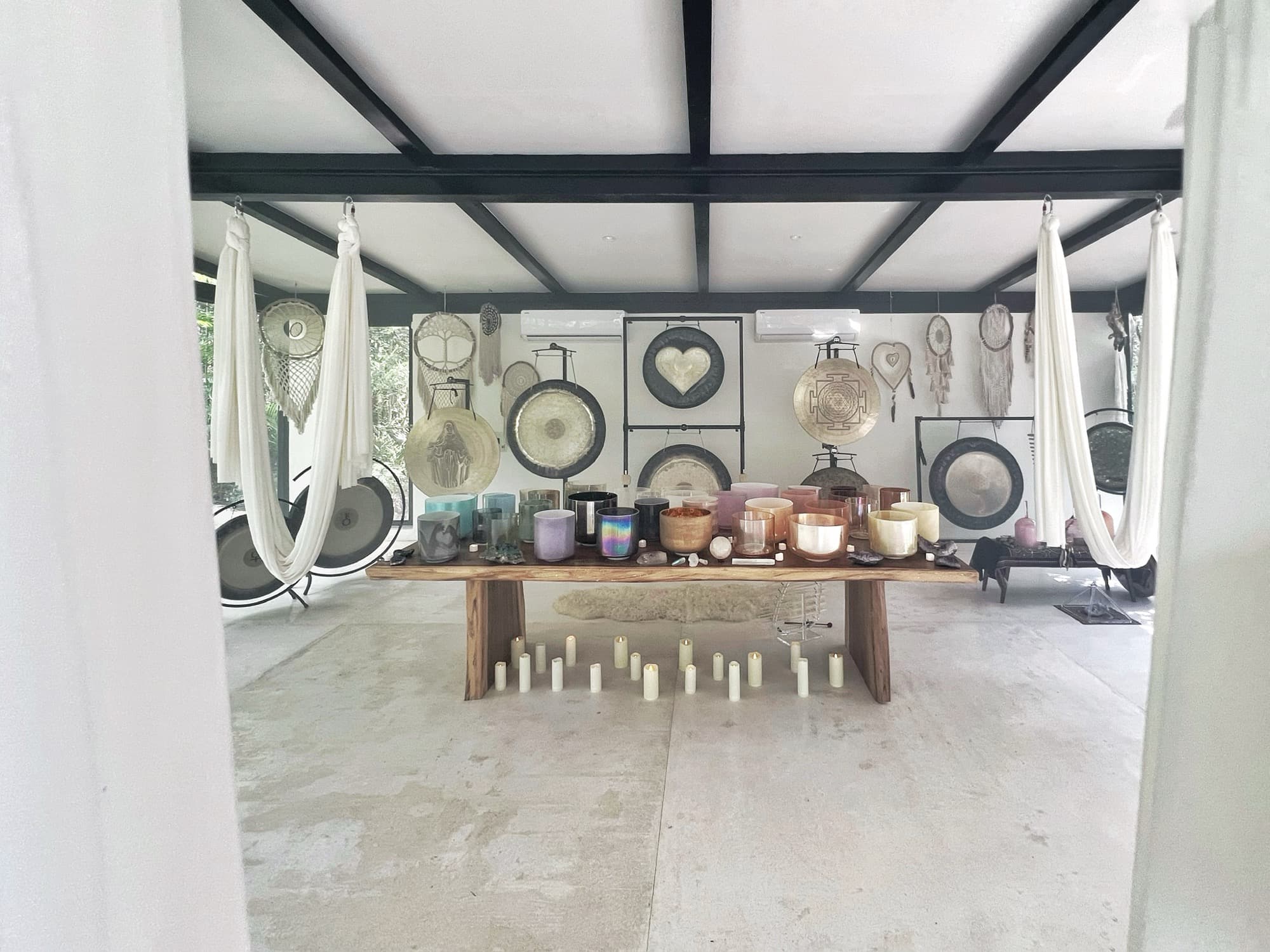 The wall of gongs behind the altar, a line of candles across the floor