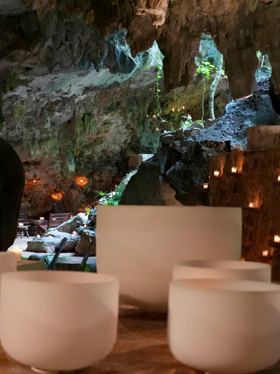 White quartz bowls before a wall of candles in the cave