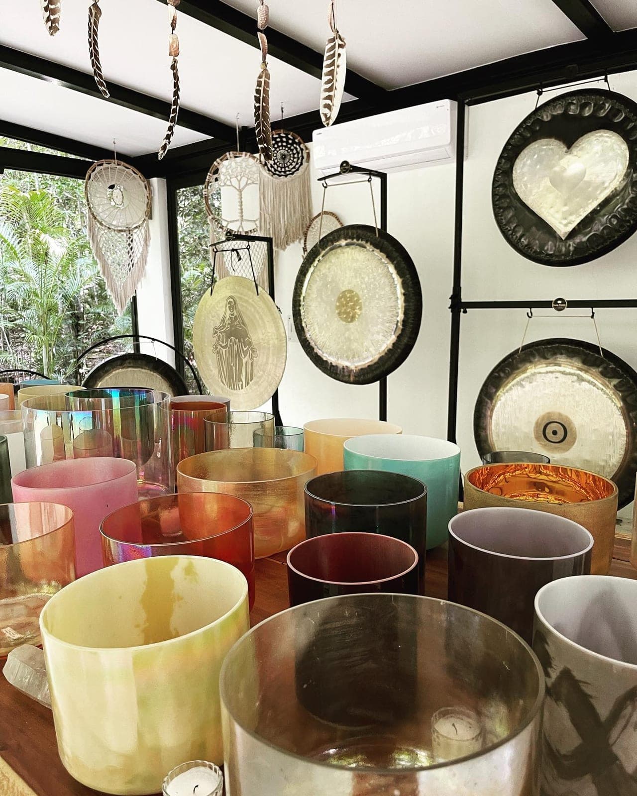 Crystal bowls beneath the sculpted heart gong and the hanging dreamcatchers of the temple