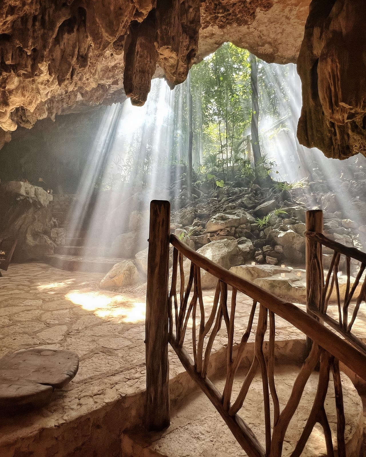 Una cortina de luz inundando la boca de la cueva bordeada de selva sobre las rocas