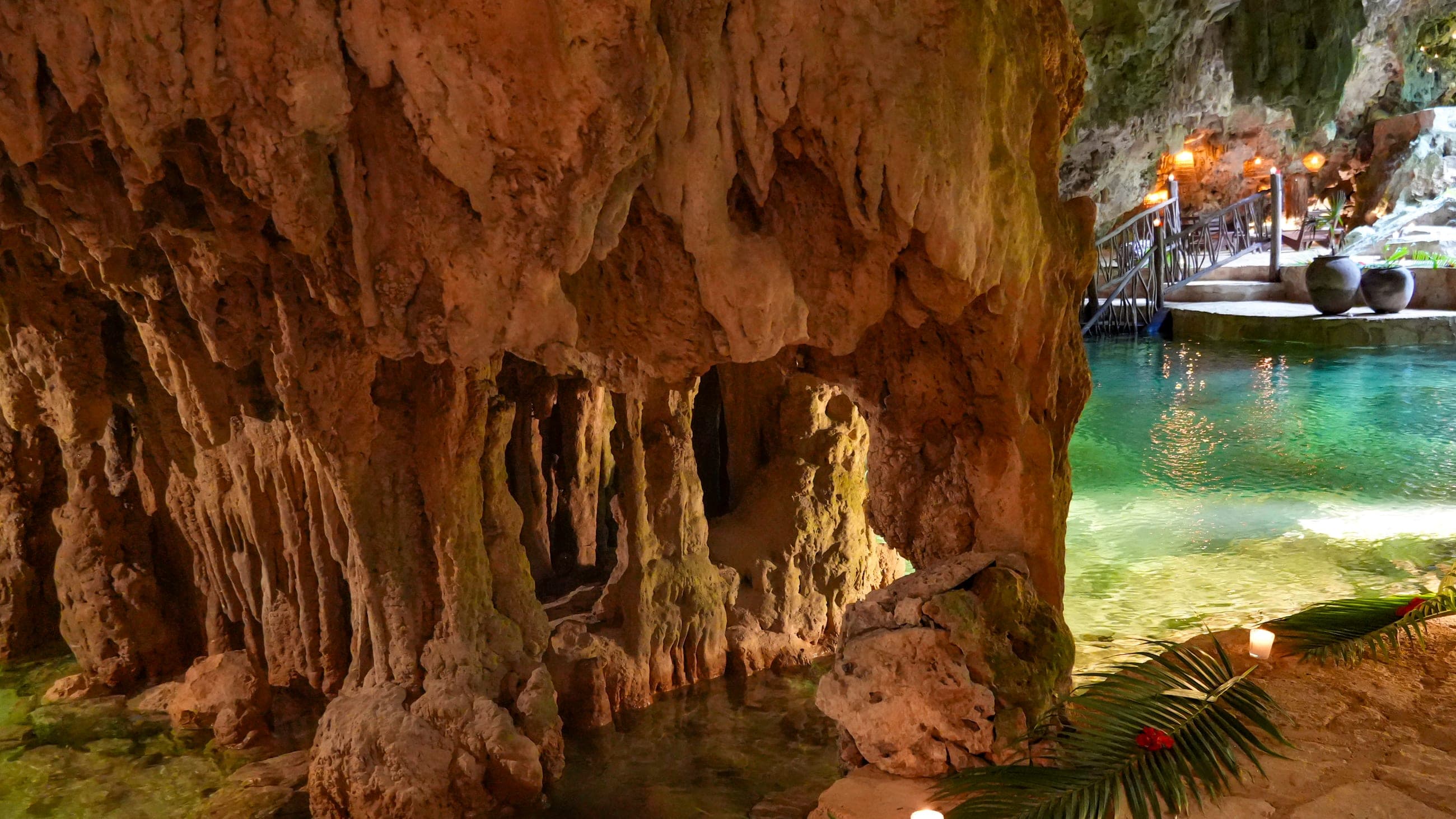A wall of stalactites above the turquoise cenote