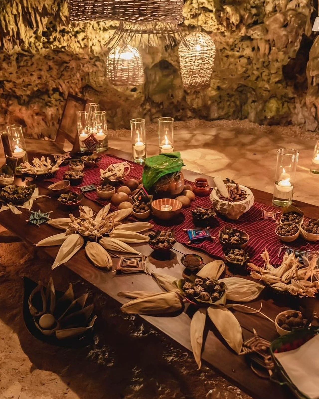 The candlelit ceremonial altar dressed with corn-husk flowers, clay vessels and cacao offerings