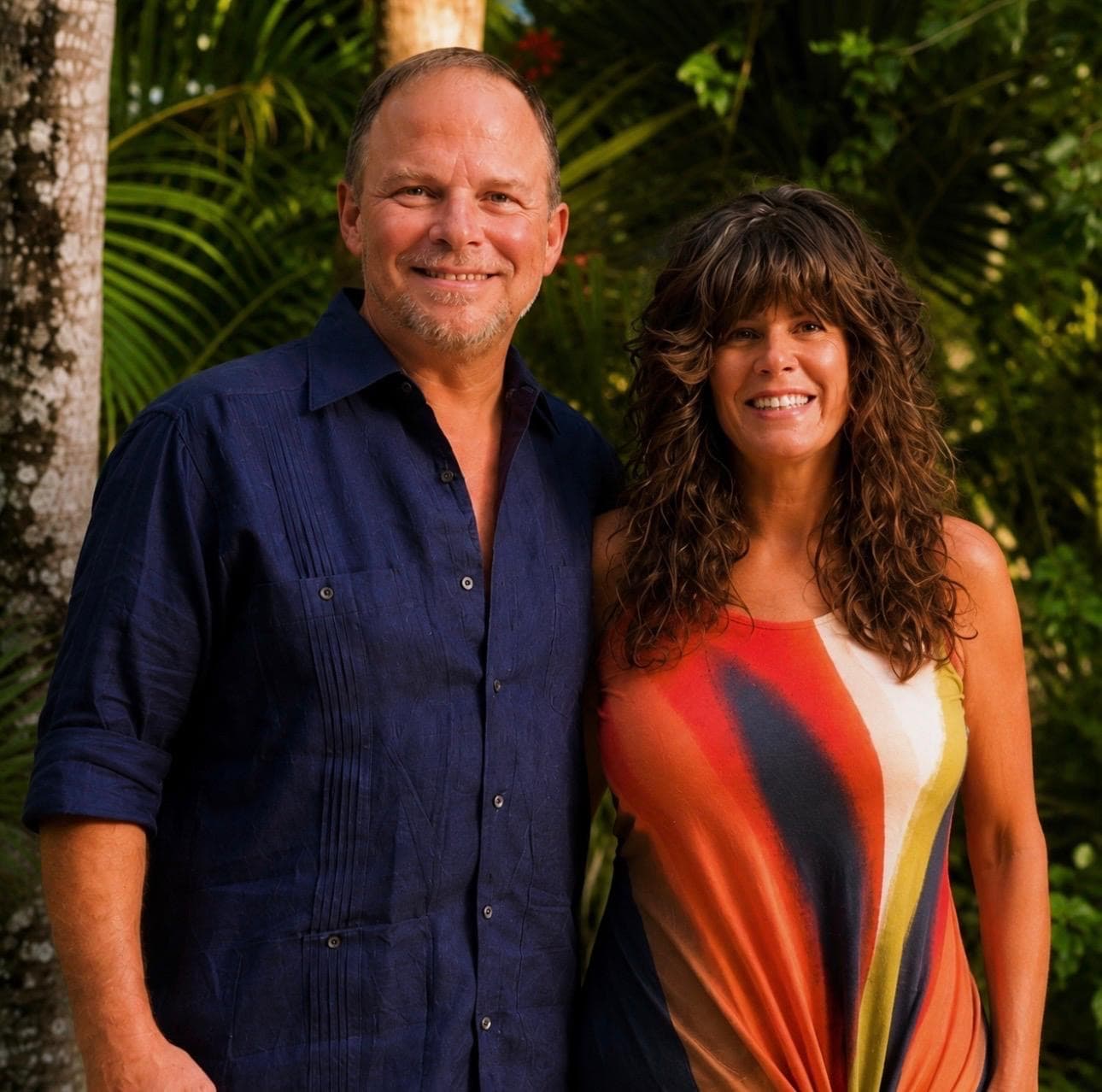 Jason and Michelle together in the jungle, palms behind them
