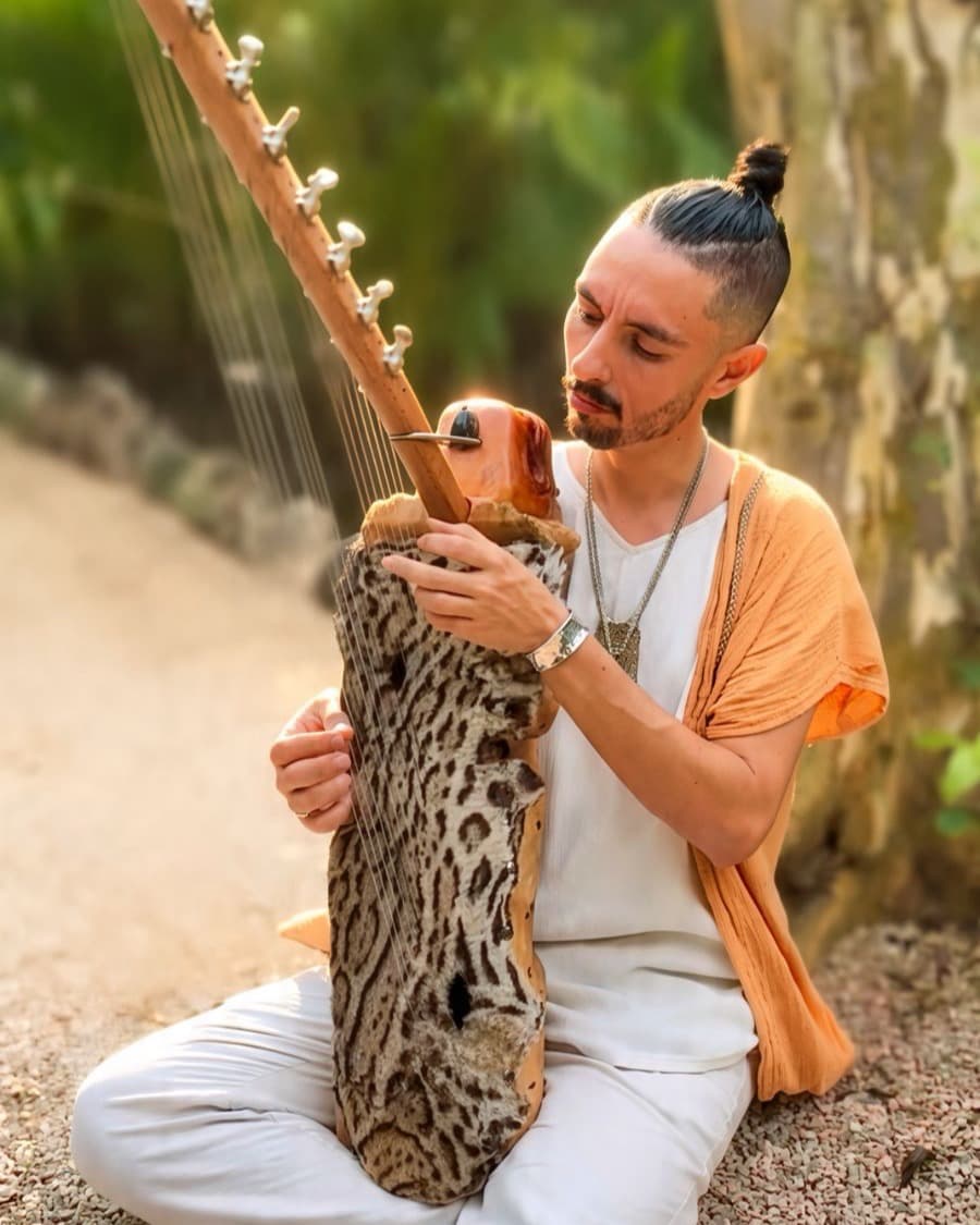 Kit Nidawi seated on the jungle path, playing his kora