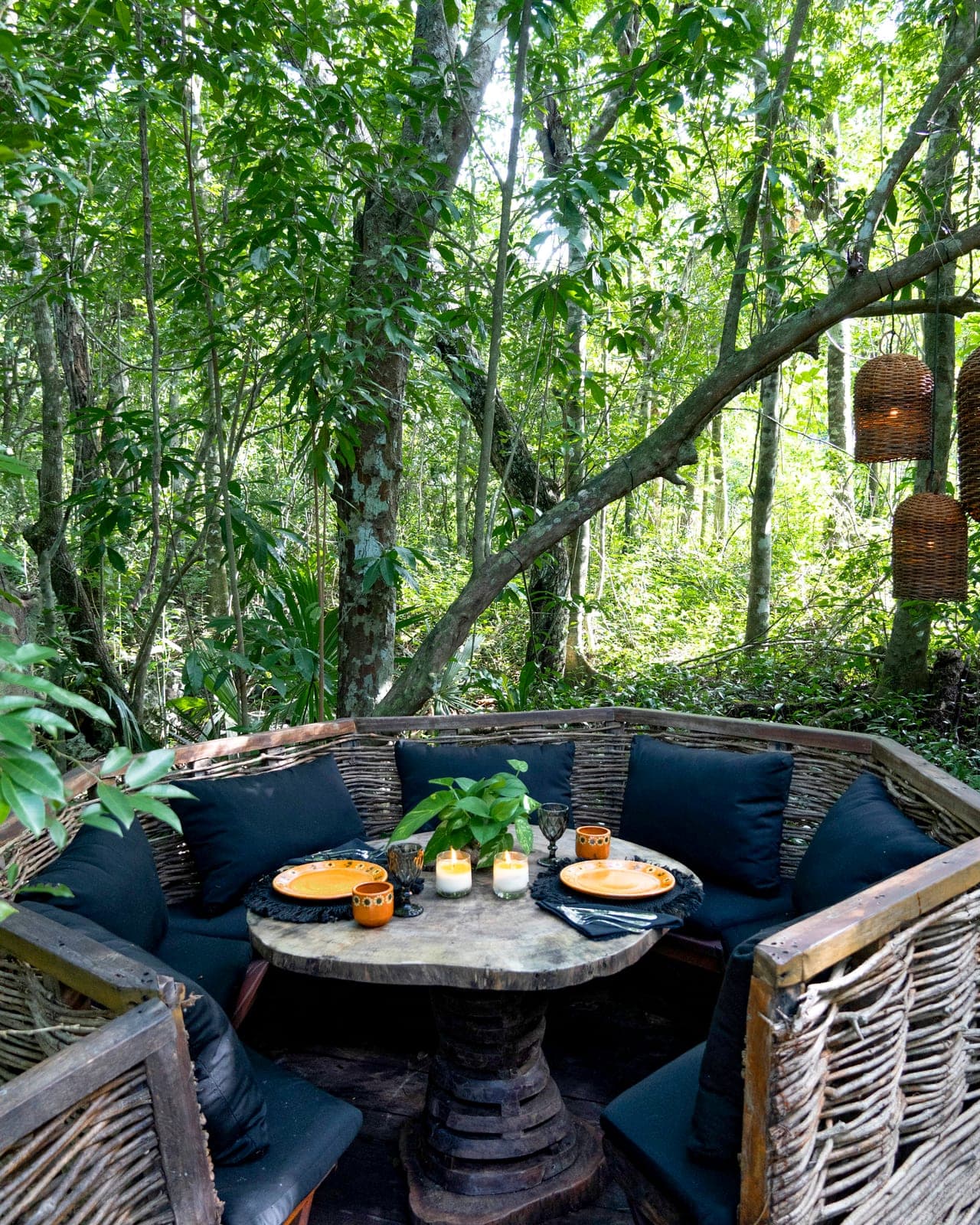 El Nido by day: the woven-branch nest with its candlelit table set in the jungle