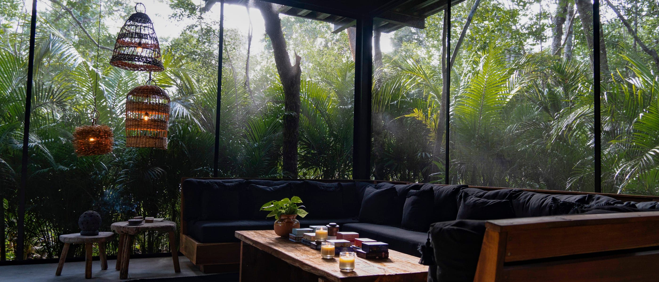 La Recepción from the jungle: sofas, candles and the canopy beyond the glass